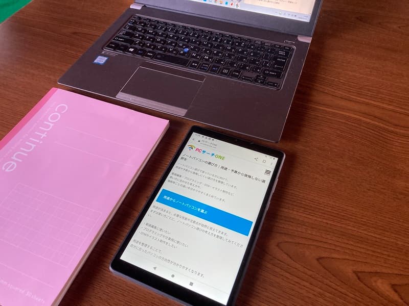 NEC LAVIE Tab E 8HD1を自宅の机に置いた使用イメージ。ノートPCと並べた実機写真